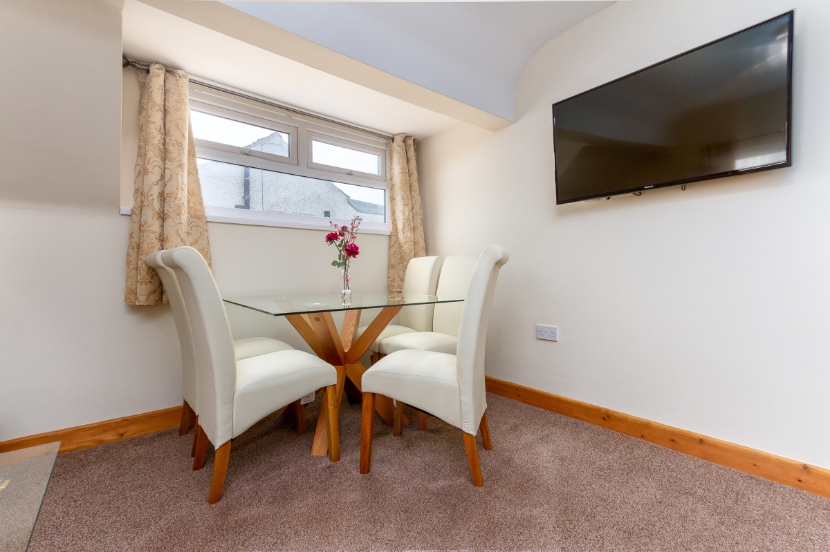 Self catering holiday apartments Blackpool. Beachcliffe apartments  7 lounge. Large double sofa bed, wall mounted TV, coffee table, Dining area with Table and chairs.