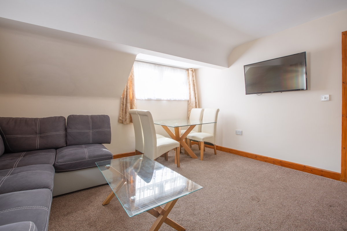 Self catering holiday apartments Blackpool. Beachcliffe apartments  7 lounge. Large double sofa bed, wall mounted TV, coffee table, Dining area with Table and chairs.